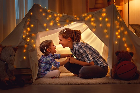 Eine Mutter mit ihrem Kind in einem Zelt im Wohnzimmer