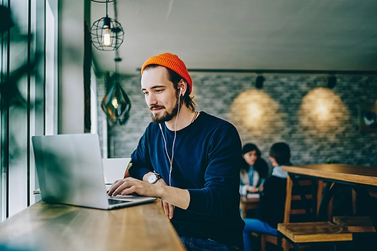 Ein junger Mann schaut auf seinen Laptop