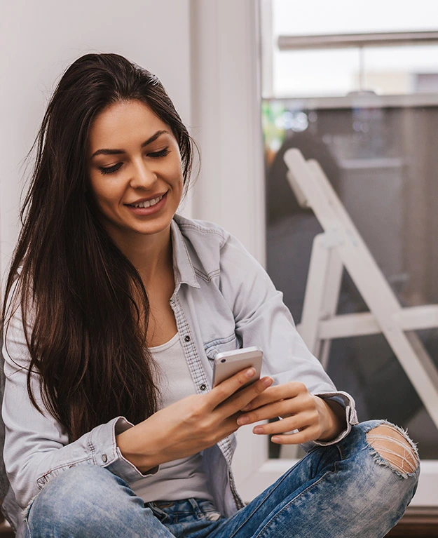 Eine junge Frau hält ihr Handy in der Hand