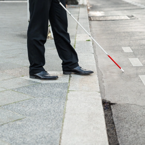 Ein blinder Mann geht über die Straße