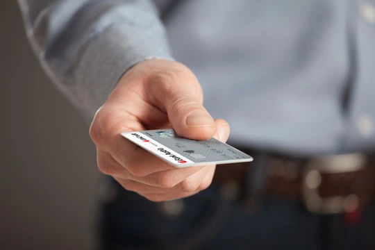 Ein Mann hält eine Bank Austria Debitkarte in der Hand