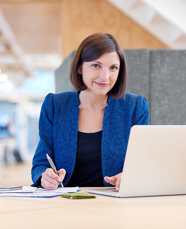 Eine Businessfrau sitzt vor ihrem Laptop