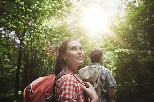 eine Frau und ein Mann im Wald bei Sonnenschein