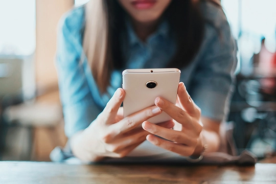 Eine Frau mit ihrem Handy in der Hand