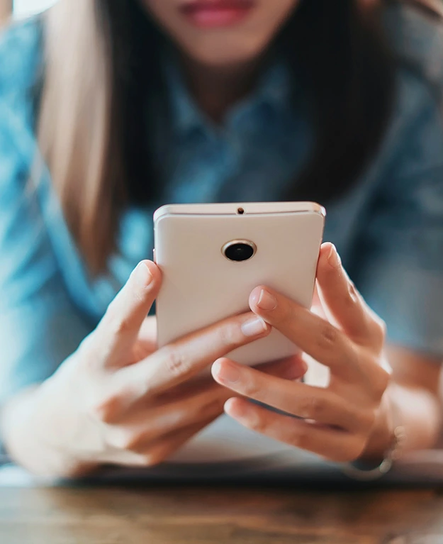 Eine junge Frau hält ein Smartphone in der Hand