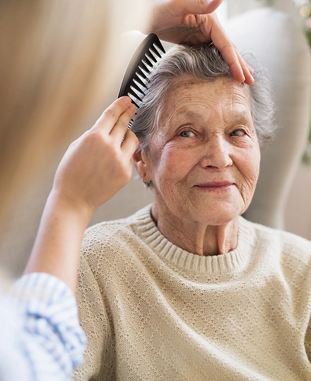 An old woman is being combed.